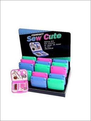 Exhibición de kits de costura compactos en varios colores; estuches rosa, azul y verde, con cartel promocional.
