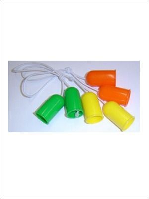Tapones para los oídos, de color verde, naranja y amarillo, unidos por un cordón blanco, sobre una superficie blanca.