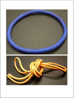 Lazo para el pelo circular de color azul encima de un lazo para el pelo anudado de color naranja.
