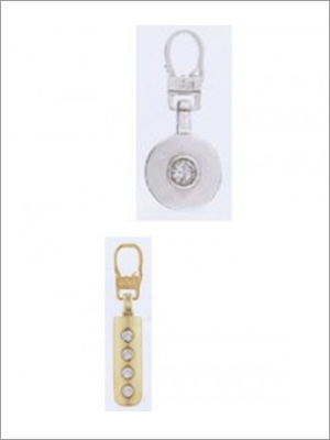 Arriba: Llavero con medallón de plata. Abajo: Llavero rectangular dorado con cuatro agujeros.