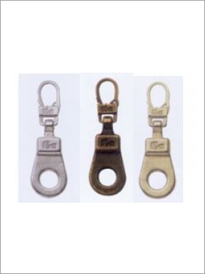 Tres tiradores de cremallera de metal: plata, bronce y oro, con un orificio circular para agarre.