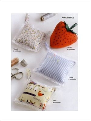 Alfiletero de lunares con alfileres clavados y adorno blanco en forma de estrella en la parte superior.