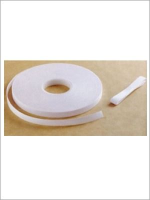 Rollo de cinta de espuma blanca con un pequeño trozo al lado.