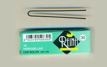 Horquilla y caja de horquillas de la marca “Reina” sobre superficie clara.