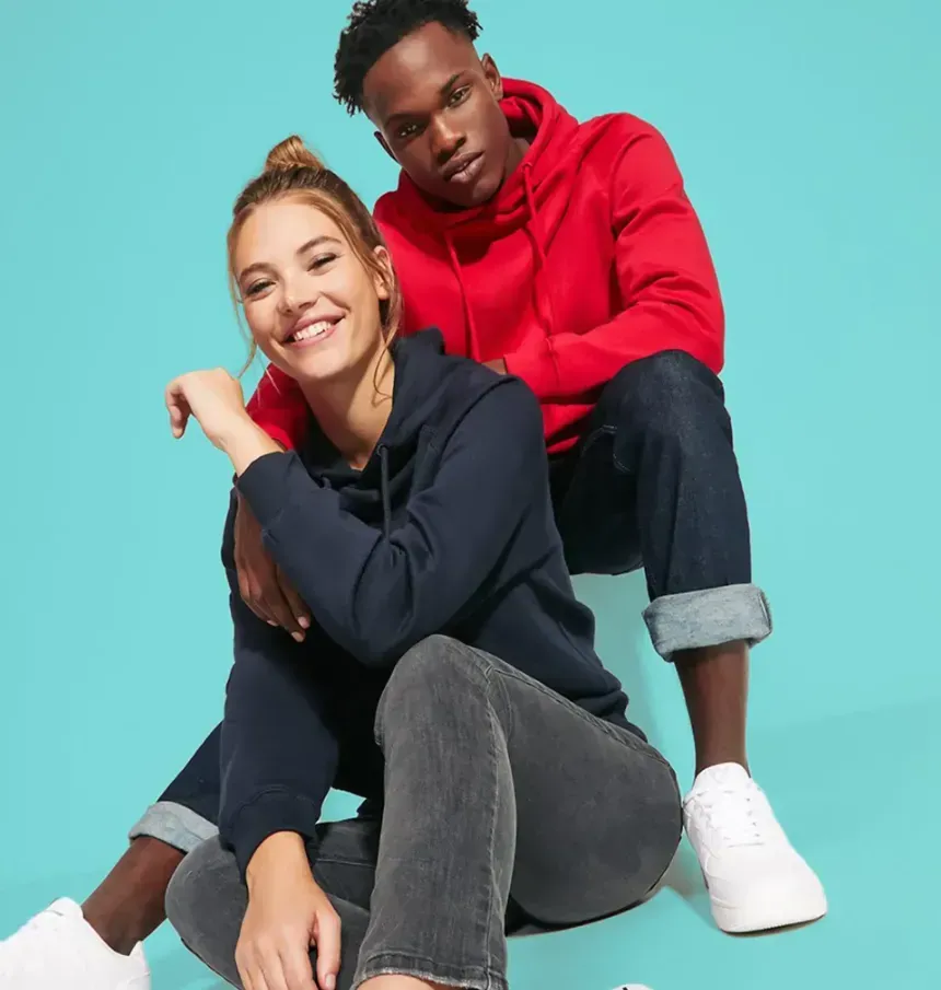 Una mujer con una sudadera con capucha azul marino sonriendo y un hombre con una sudadera con capucha roja