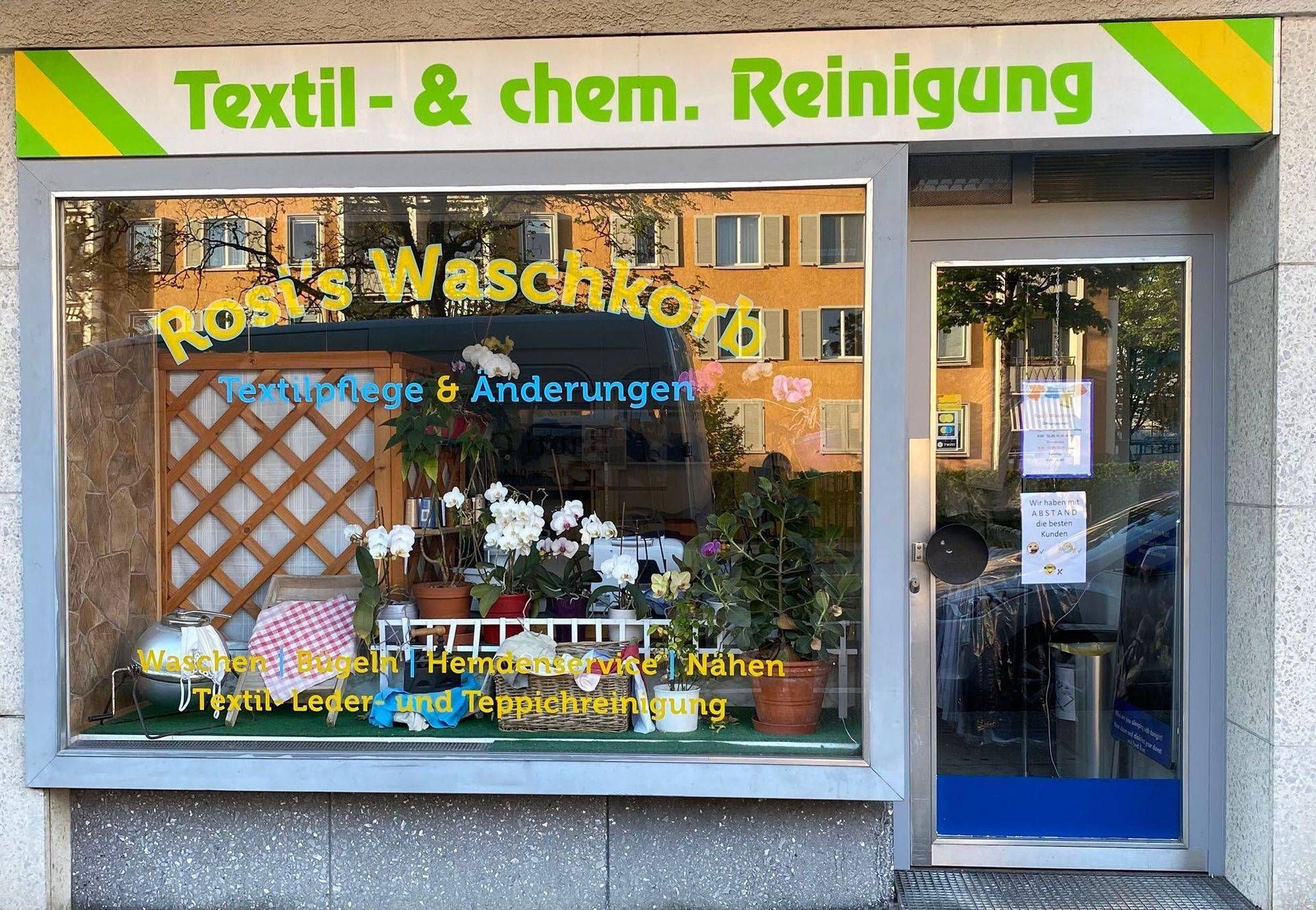 Ein Staubsauger steht auf einem Holzboden neben einem Teppich.