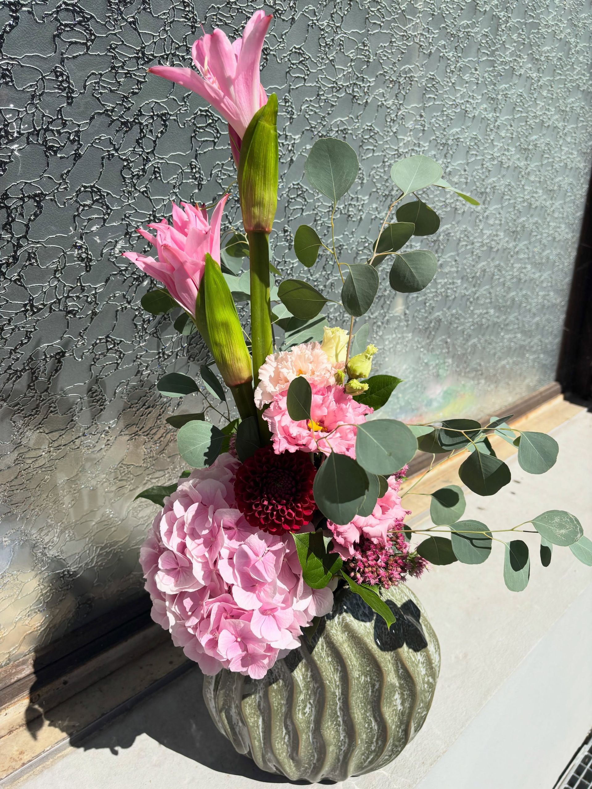 Des roses pêche et roses en pleine floraison, avec une grande rose pêche au centre, parmi des pétales délicats.