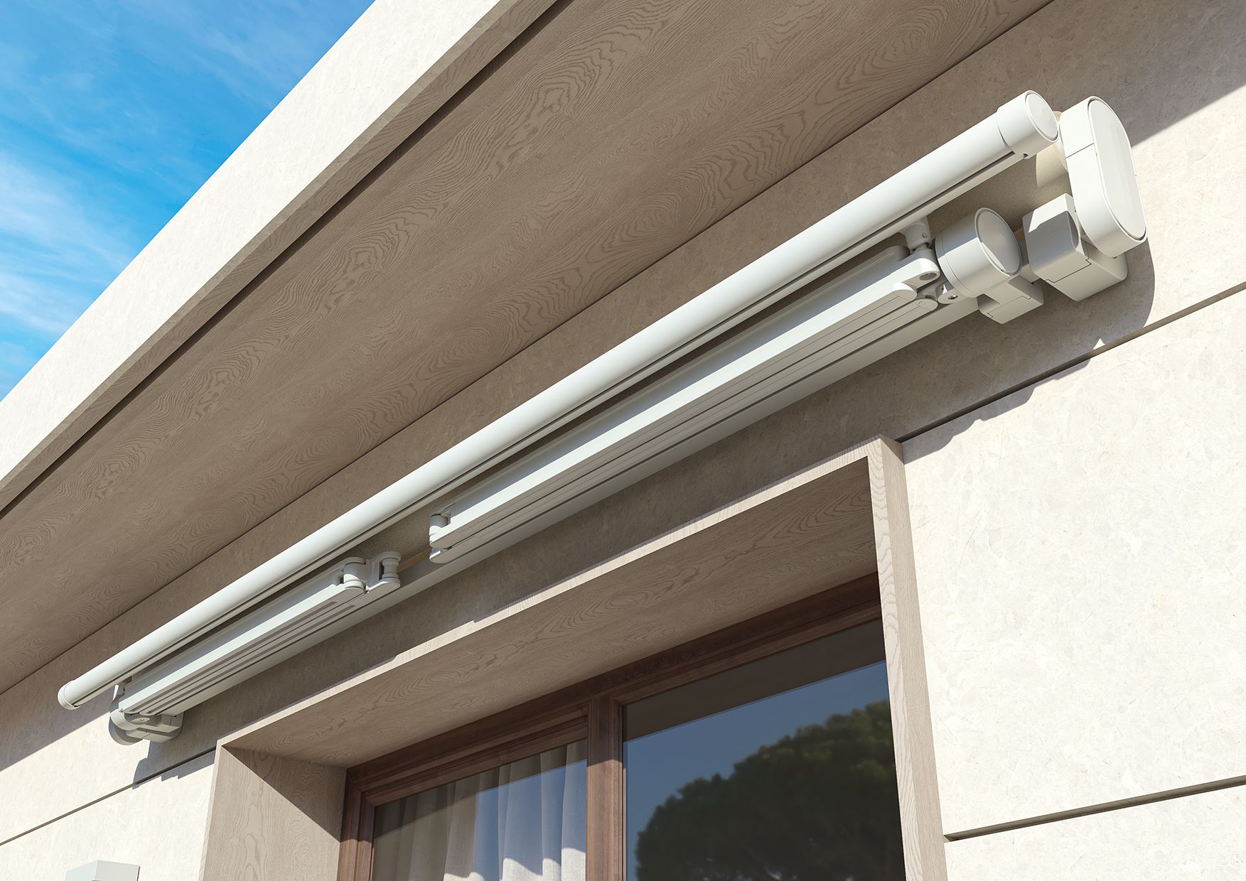 Una tenda da sole retrattile bianca montata sulla parete esterna in stucco beige di un edificio, sopra una finestra.