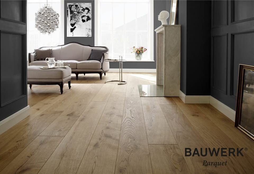 Elegante soggiorno con pavimento in legno di rovere chiaro, pareti grigie, divano e camino, firmato Bauwerk Parquet.
