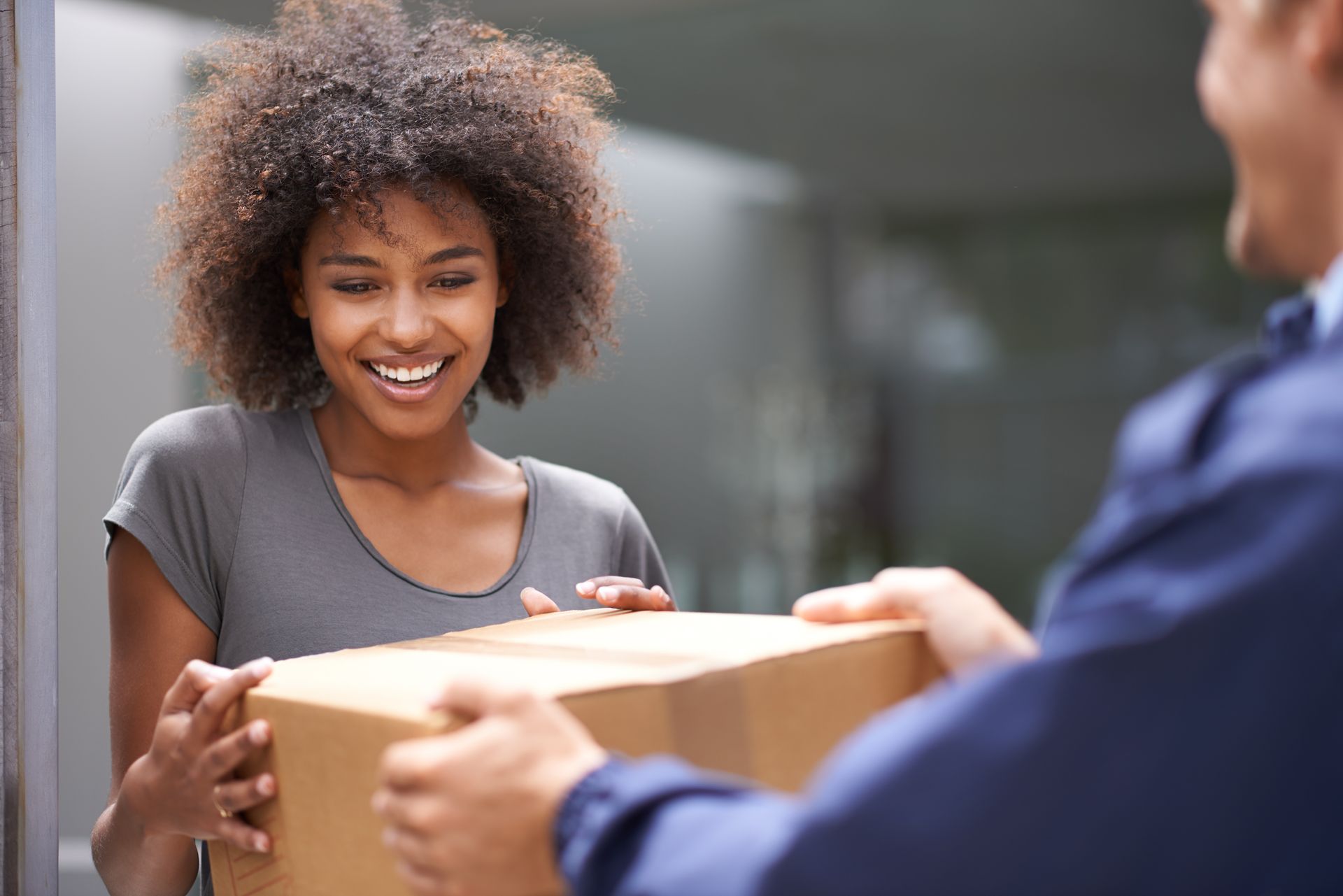 Une cliente souriante recevant un colis