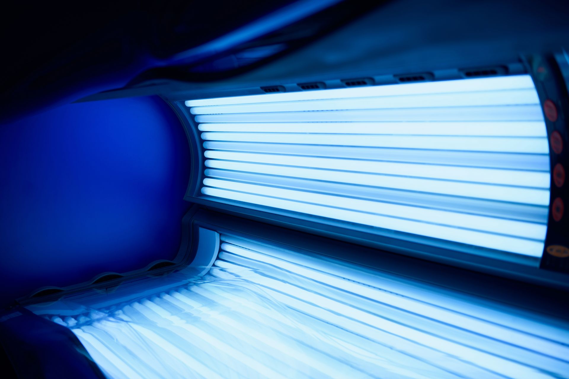 Lit de bronzage bleu avec des lampes UV lumineuses, en gros plan.