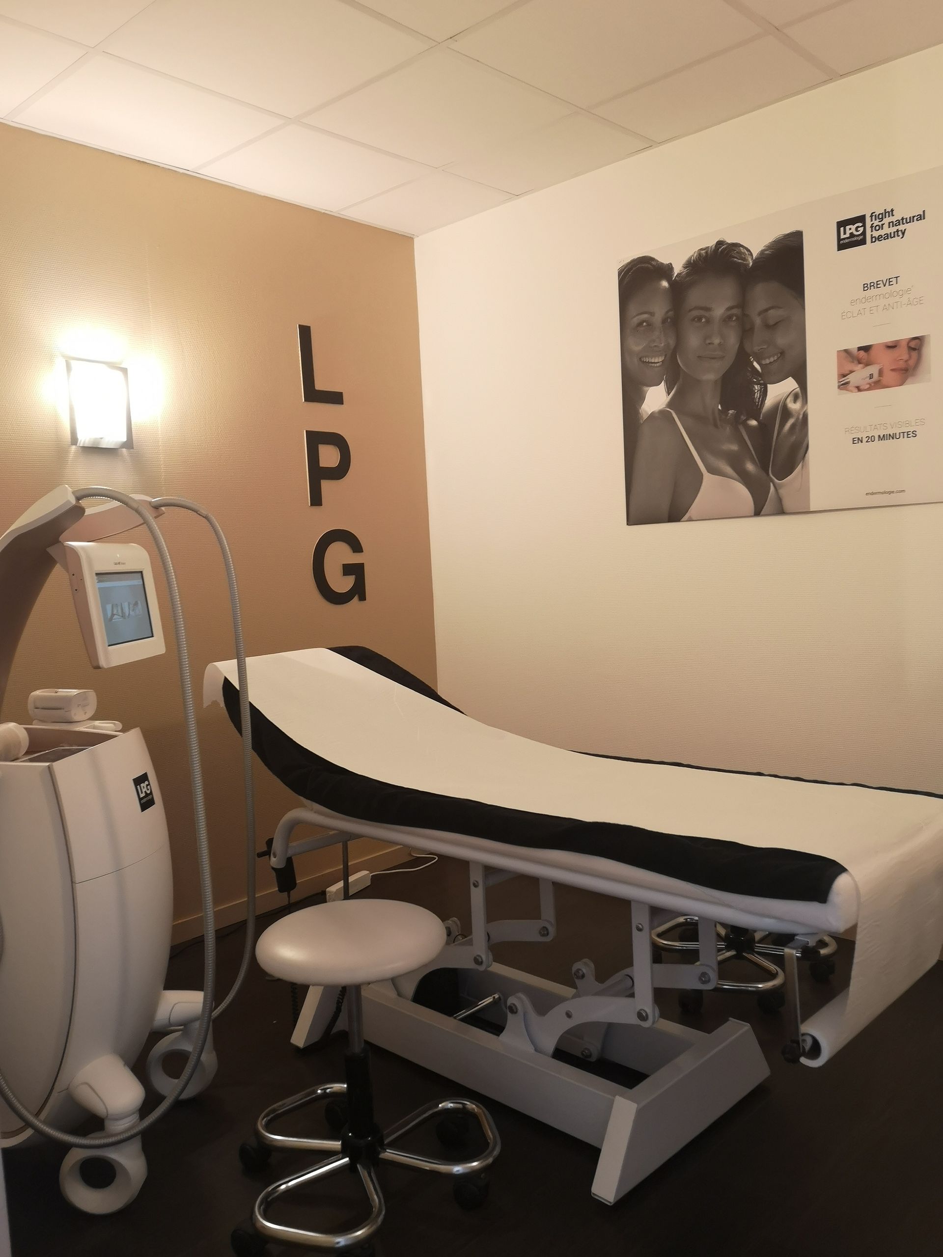 Salle d’examen d’une clinique avec une table de soins, du matériel médical et une affiche murale, le tout baigné d’une lumière chaleureuse.