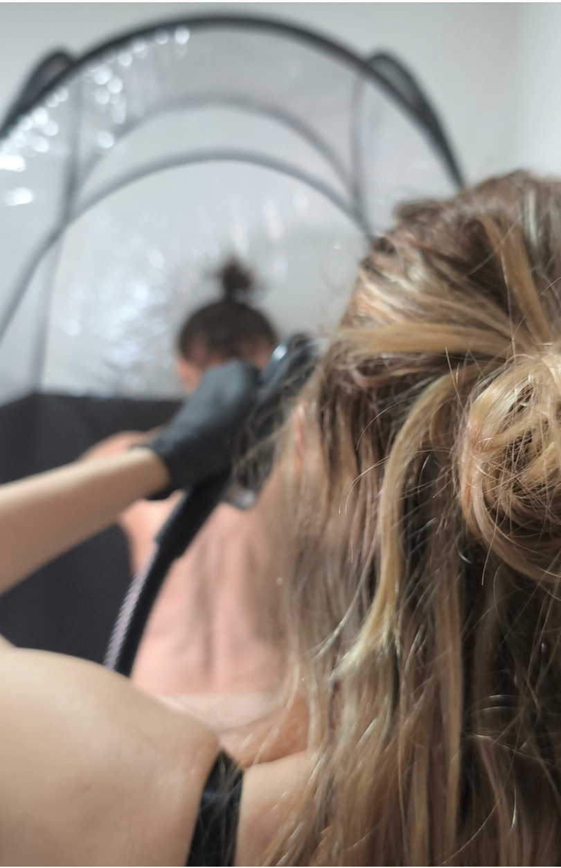Femme utilisant un Spray Tan sur une autre femme.