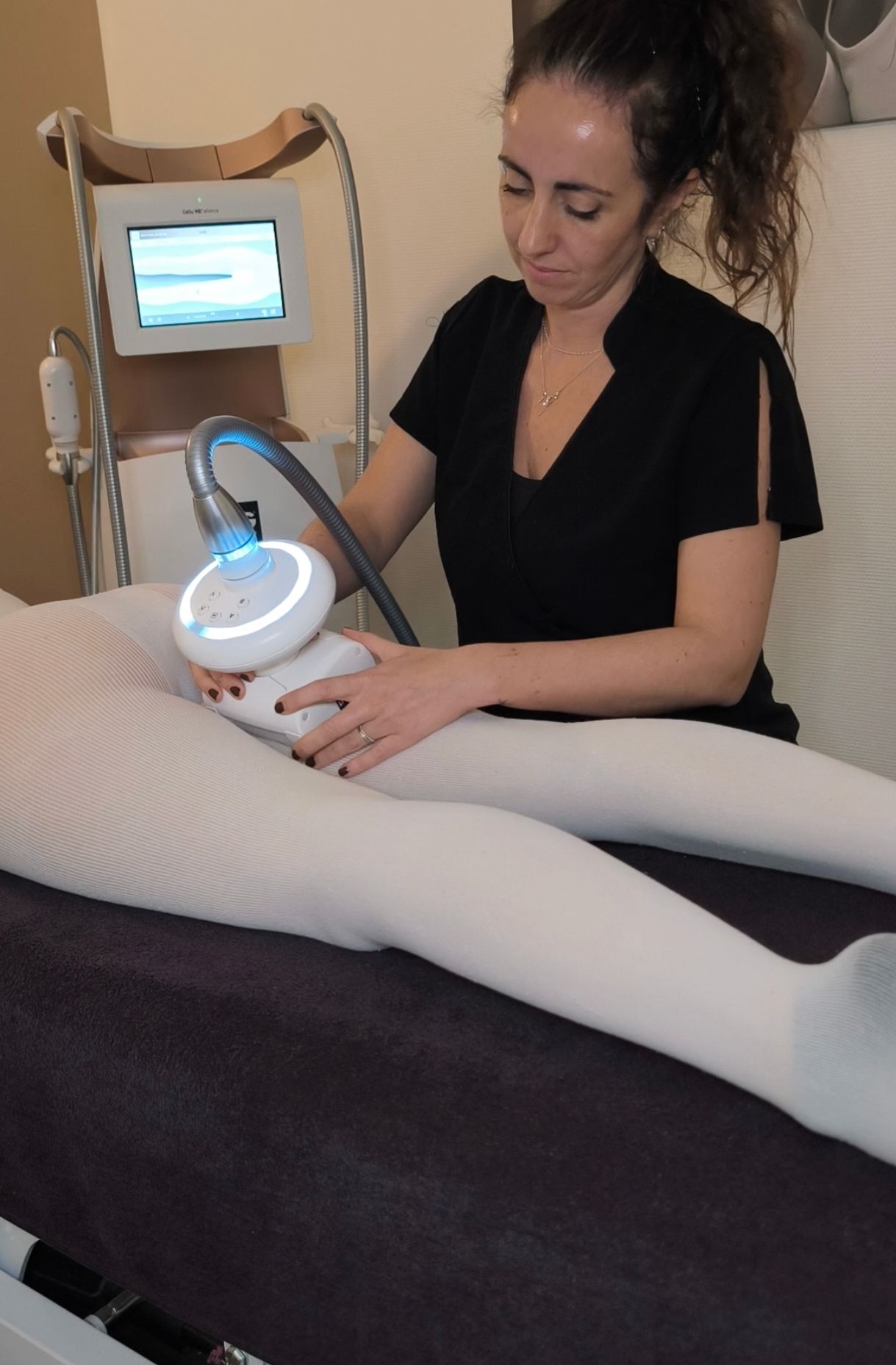 Une femme utilisant un appareil de soin portatif sur la jambe d’une cliente