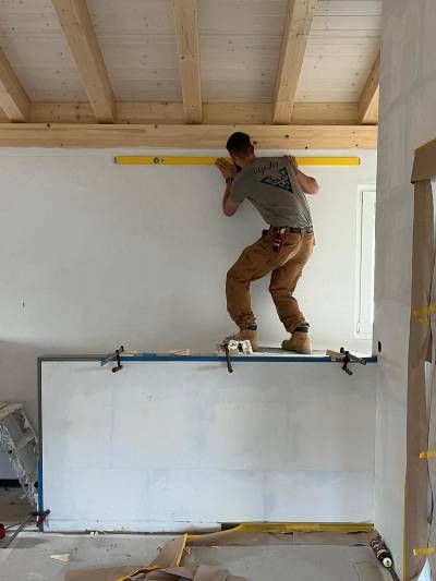 Un homme mesure un mur avec un niveau