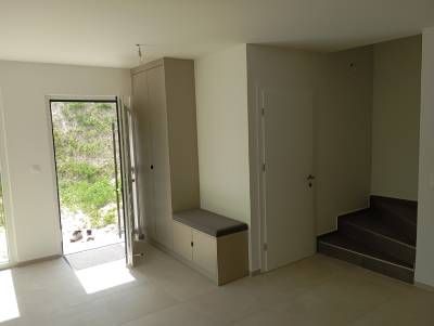 Un salon avec une porte ouverte et un escalier menant au deuxième étage.