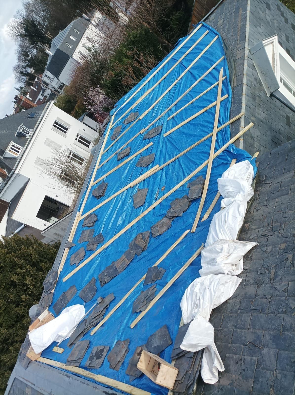 Une toiture en ardoise avec un isolant visible.