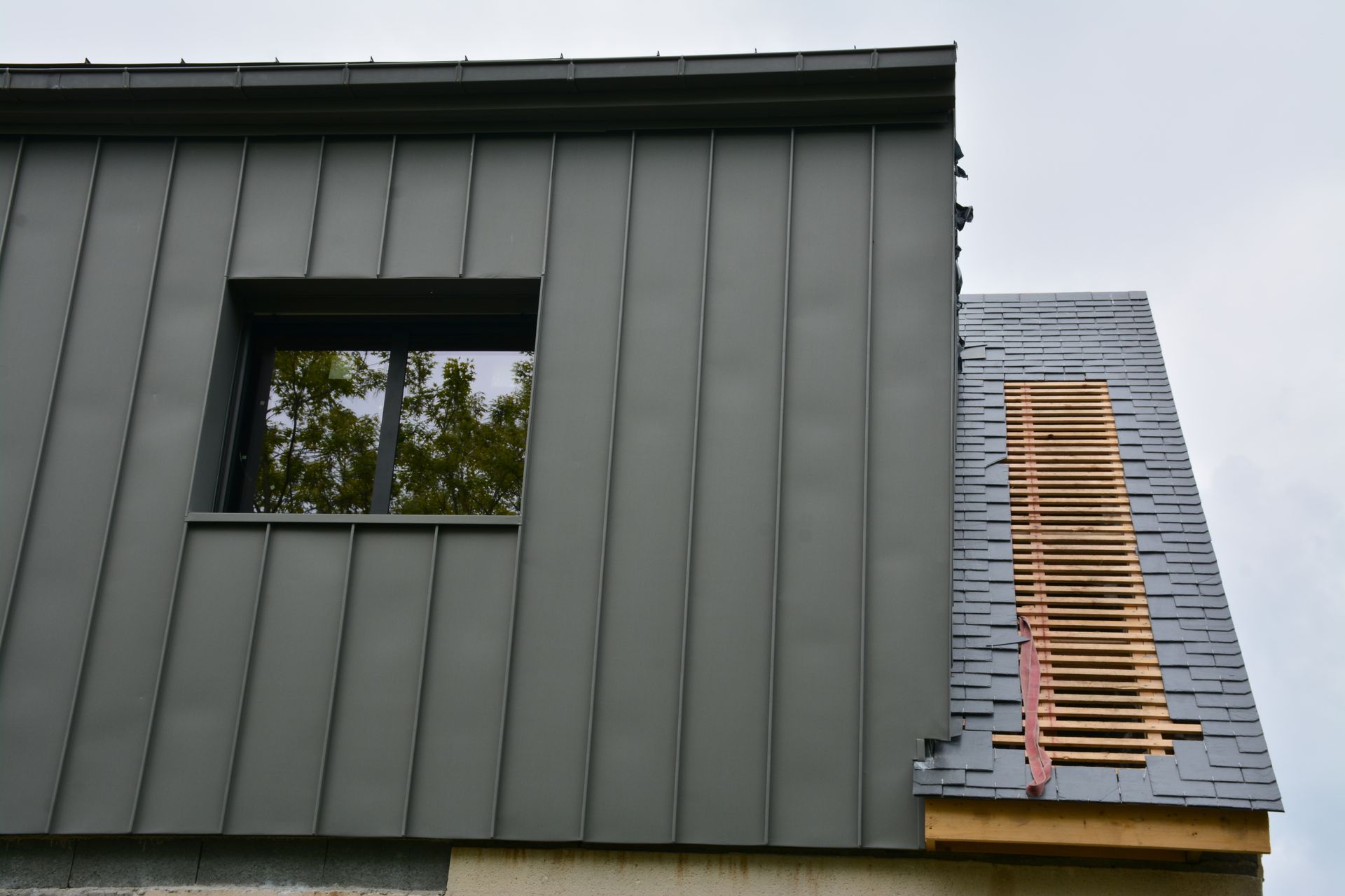 Extension de maison avec un bardage en tôle bac acier.