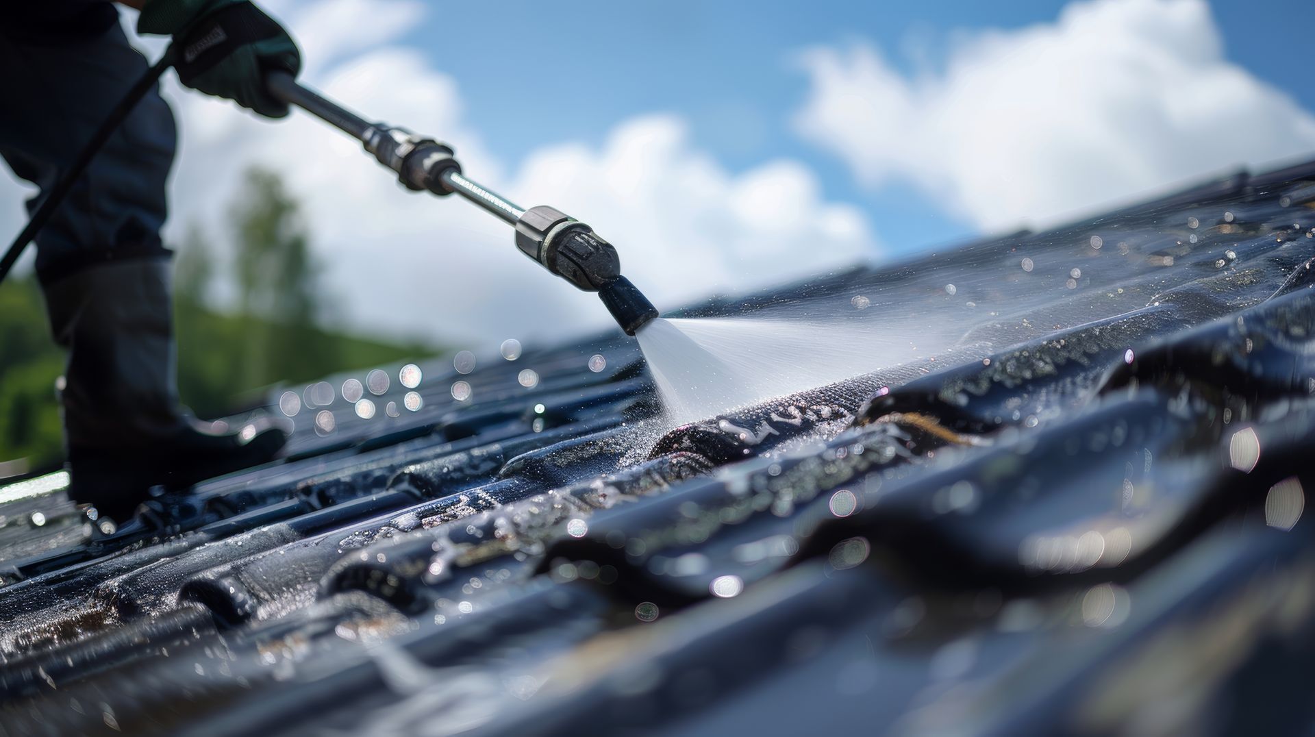 Une personne qui applique un produit hydrofuge sur une toiture en tuile.