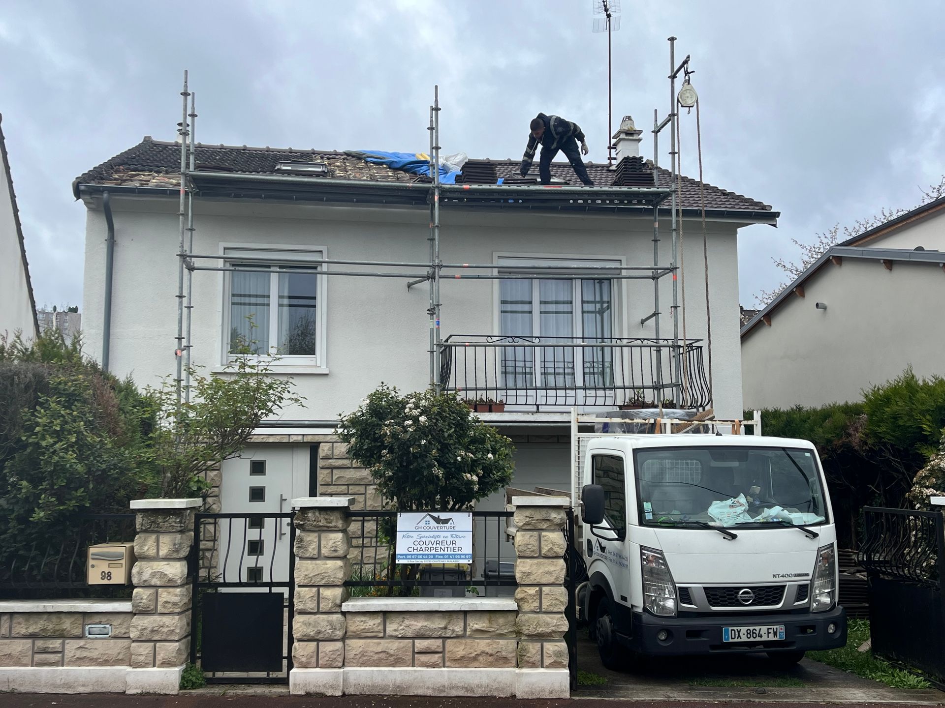 Maison individuelle avec un échafaudage devant et une camionnette de travaux.