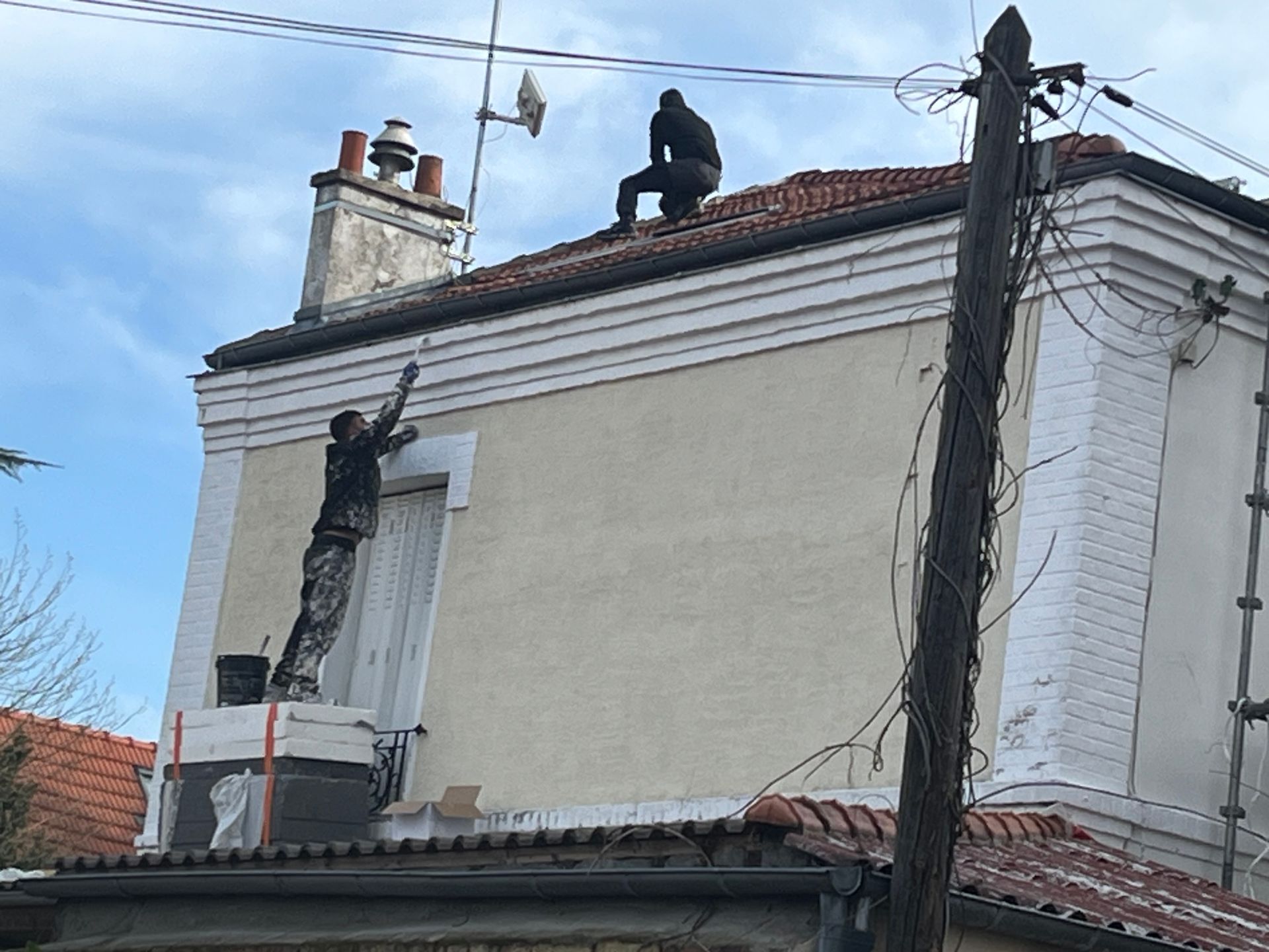 Des professionnels intervenant sur une maison pour les travaux de couverture.