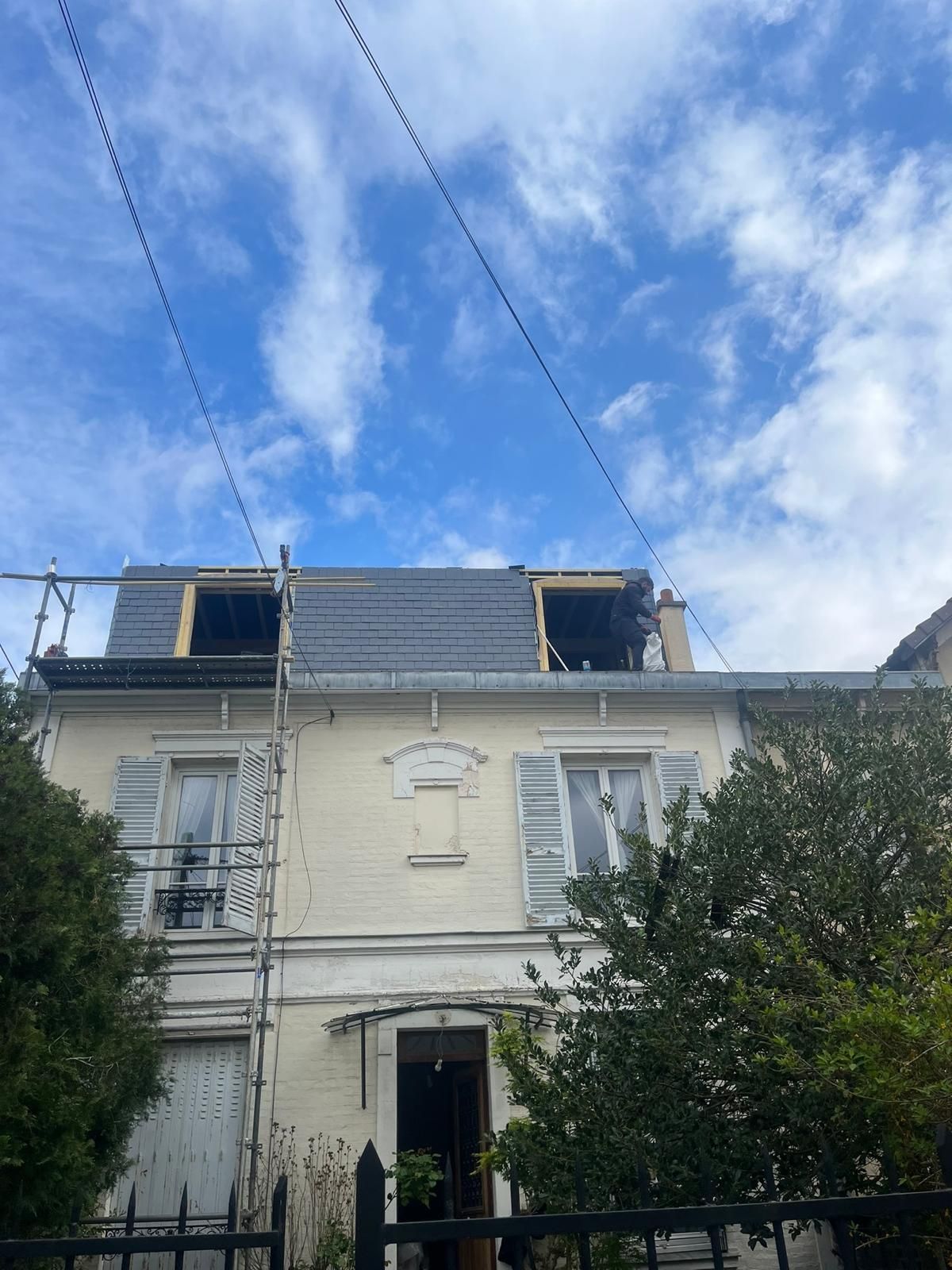 Une maison à étage avec une toiture en ardoise.