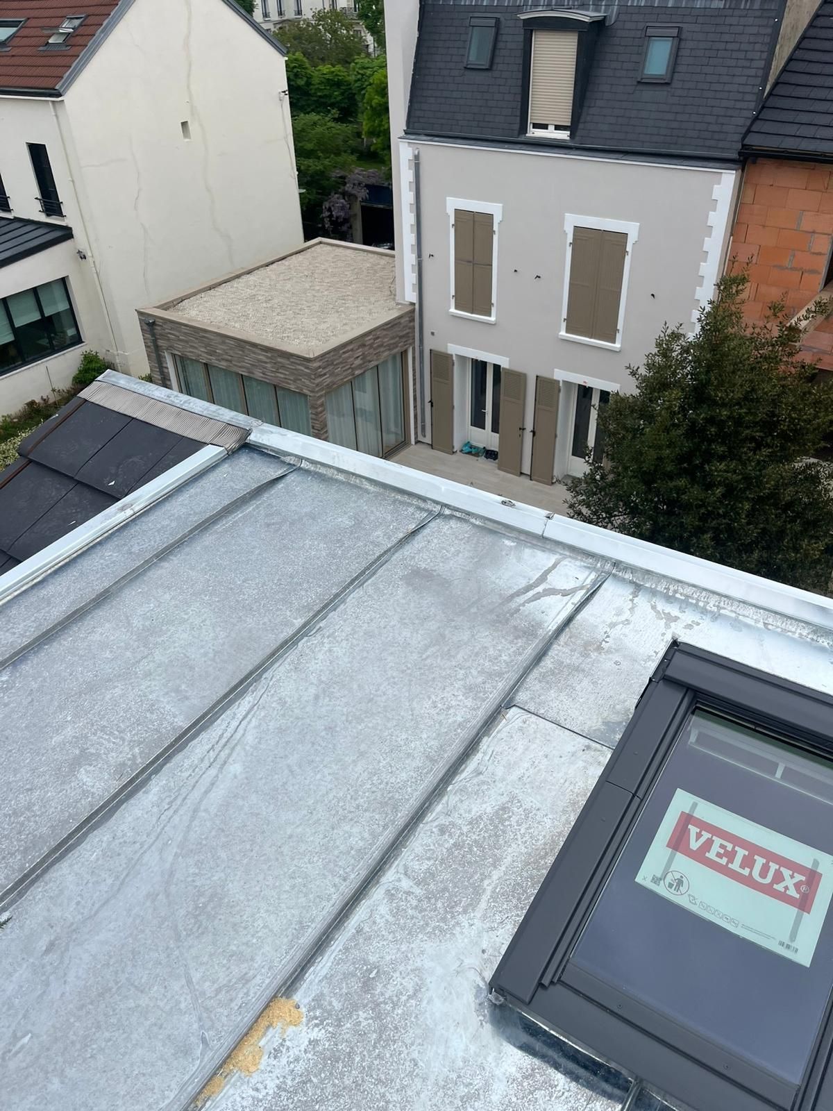 Toiture en tôle bac acier avec une fenêtre Velux.