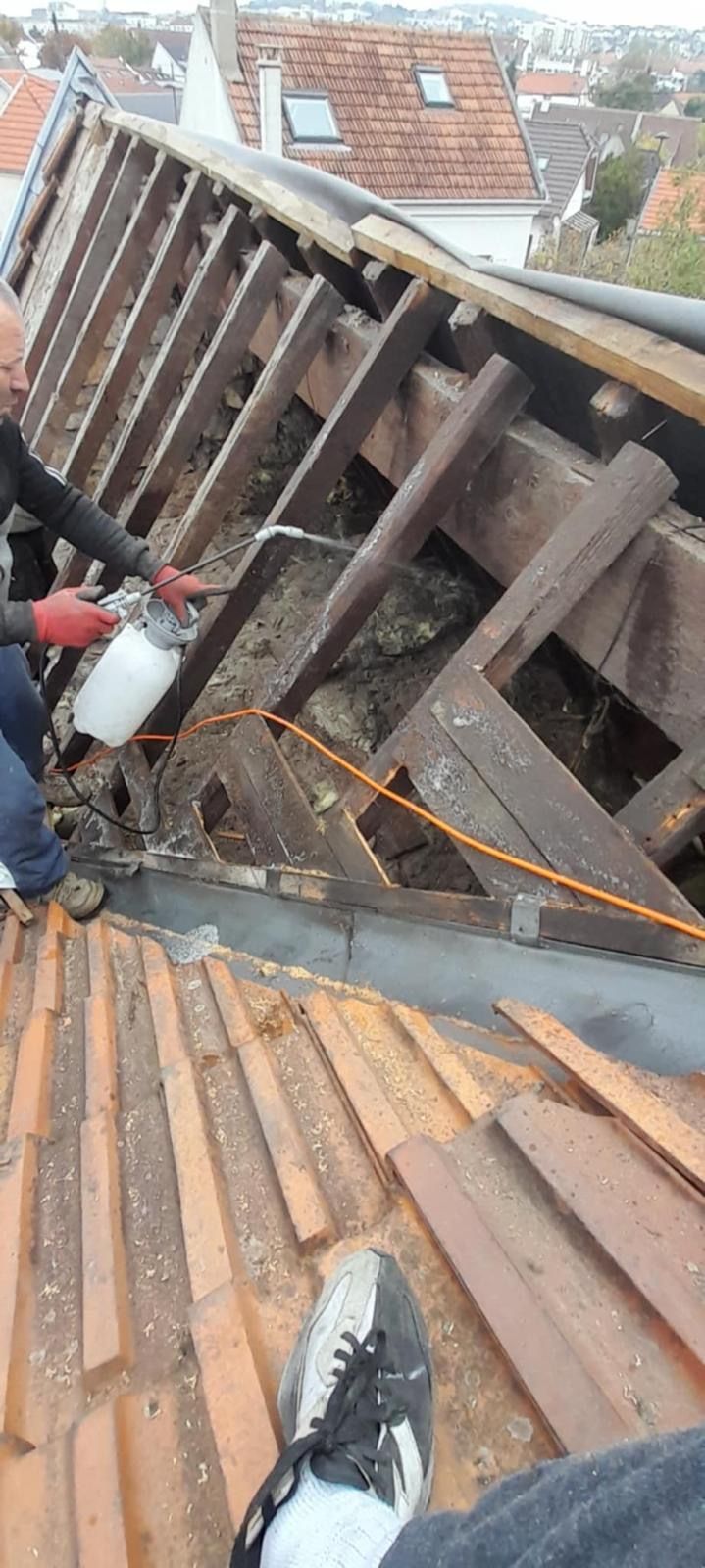 Une personne en train de traiter le bois de charpente.