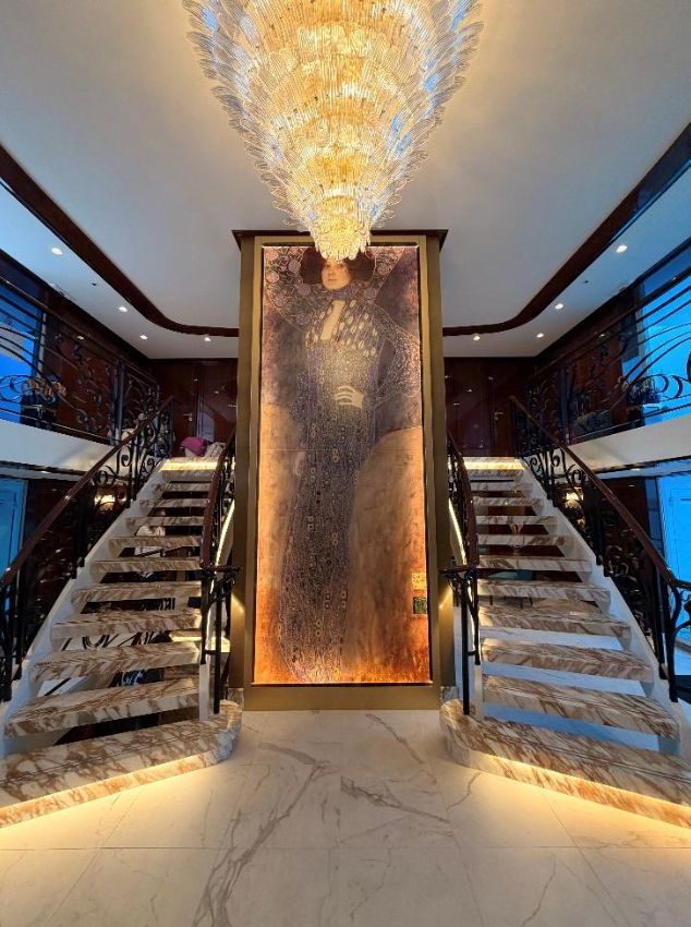 City skyline along a lake at sunset with a tall church steeple, under a vibrant, colorful sky.