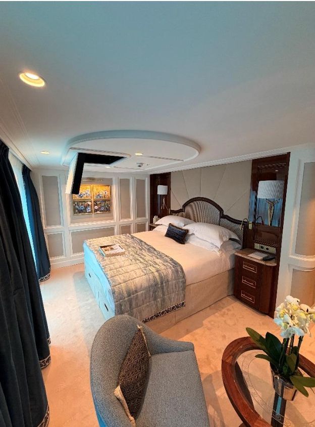 City skyline along a lake at sunset with a tall church steeple, under a vibrant, colorful sky.