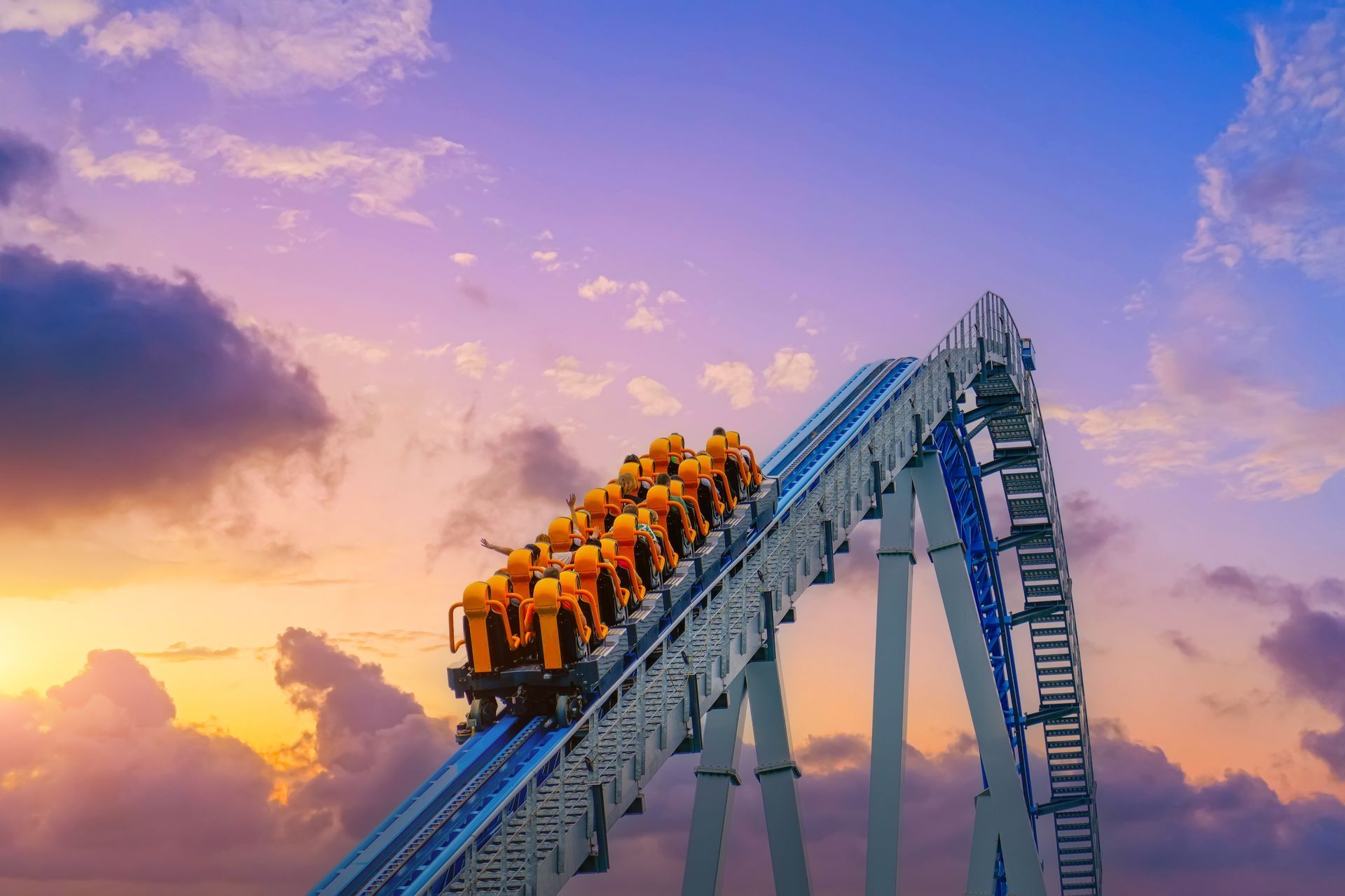 City skyline along a lake at sunset with a tall church steeple, under a vibrant, colorful sky.