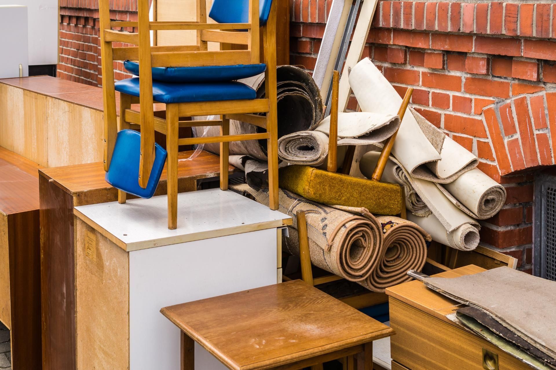 Ein Stapel Möbel und Teppiche neben an einer Hauswand angelehnt