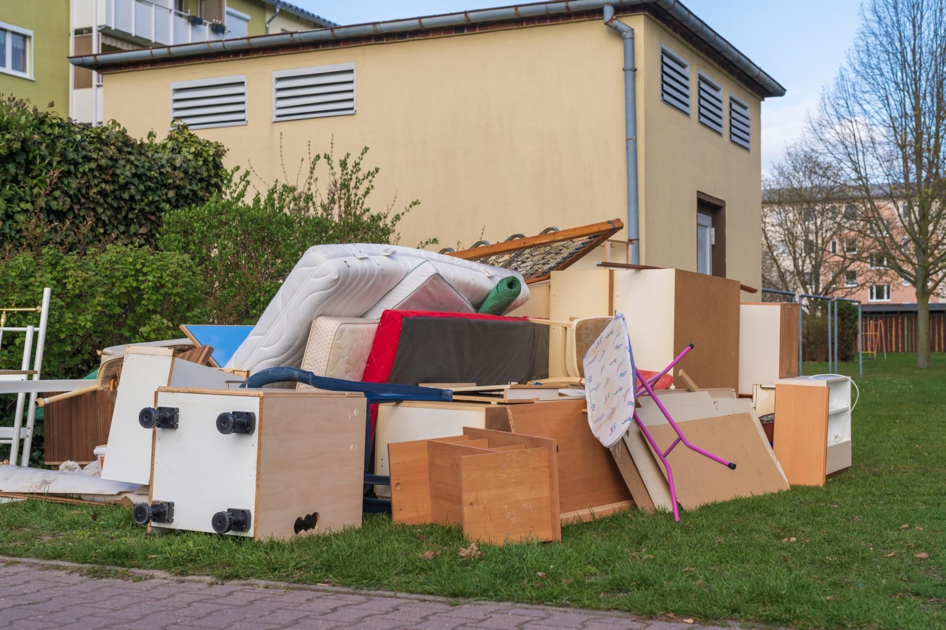 Ein Haufen Möbel liegt auf dem Rasen vor einem Haus