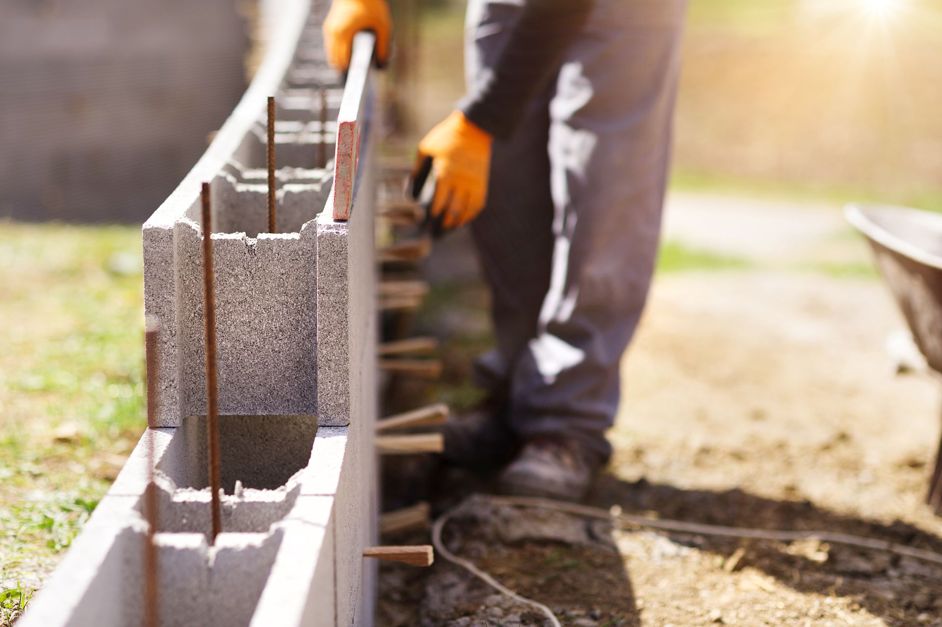 Ouvrier posant des blocs de béton sur un mur de construction à l'extérieur
