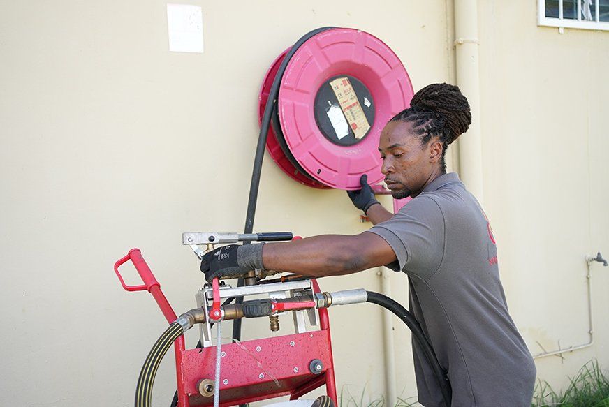 Homme qui teste un RIA (robinet d'incendie armée) avec un testeur de RIA