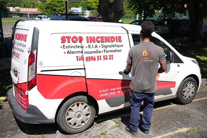 Voiture de l'entreprise Stop Incendie avec salarié qui ouvre une porte