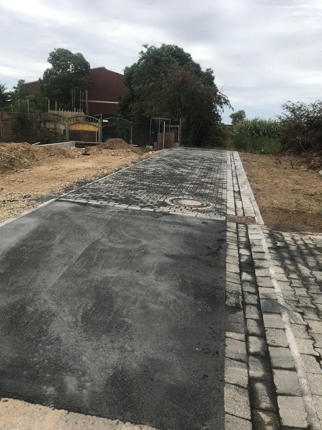 Neben einem LKW liegt ein Gullydeckel auf dem Boden.