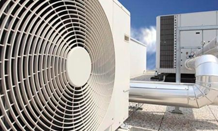 Un gran aparato de aire acondicionado está situado encima de un edificio.