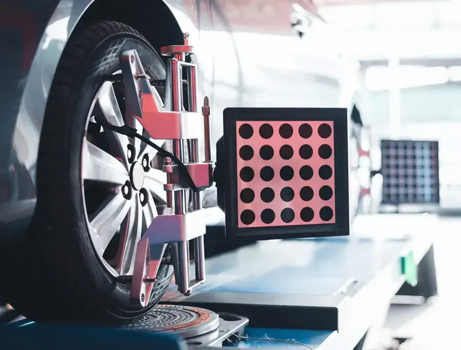 Rueda de automóvil durante una verificación de alineación en un taller, utilizando un equipo de diagnóstico.