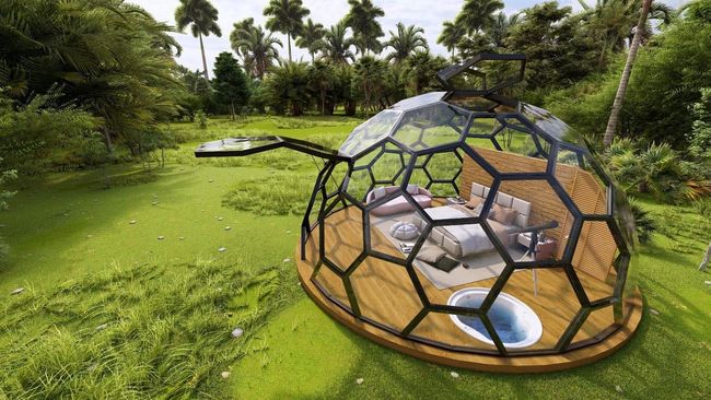 Una cúpula con una cama en su interior se encuentra sobre un exuberante campo verde.