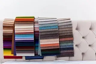 Muestras de tela en varios colores expuestas sobre una cabecera con botones.