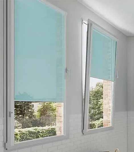 Dos ventanas con persianas azules que cubren parcialmente la vista de un jardín.