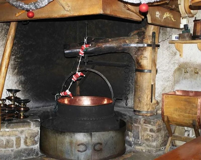 Un pot en cuivre est posé devant une cheminée avec la lettre c dessus