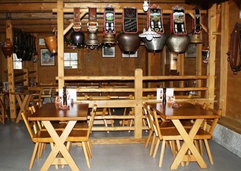 Un restaurant avec des tables, des chaises et des cloches au mur