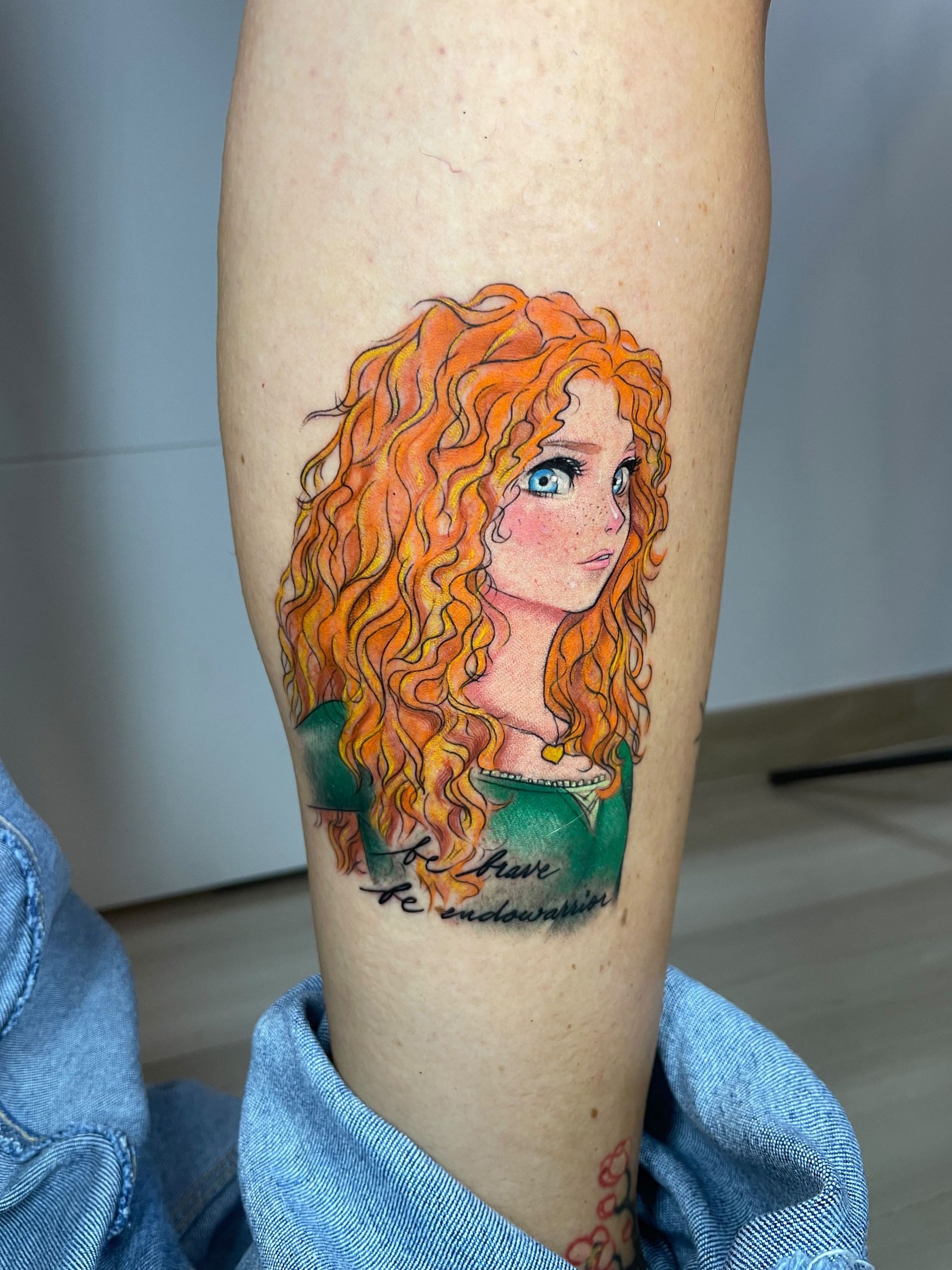 Tatuaje colorido del perfil de una mujer de cabello rizado en la parte inferior de la pierna.
