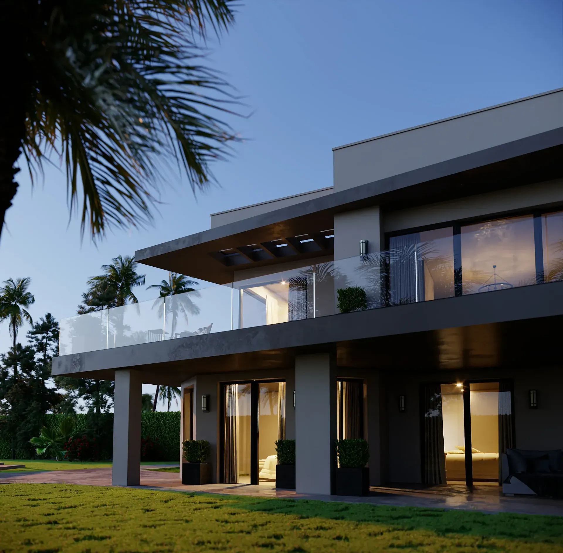 Villa moderna al atardecer con balcones de cristal, palmeras y césped verde.
