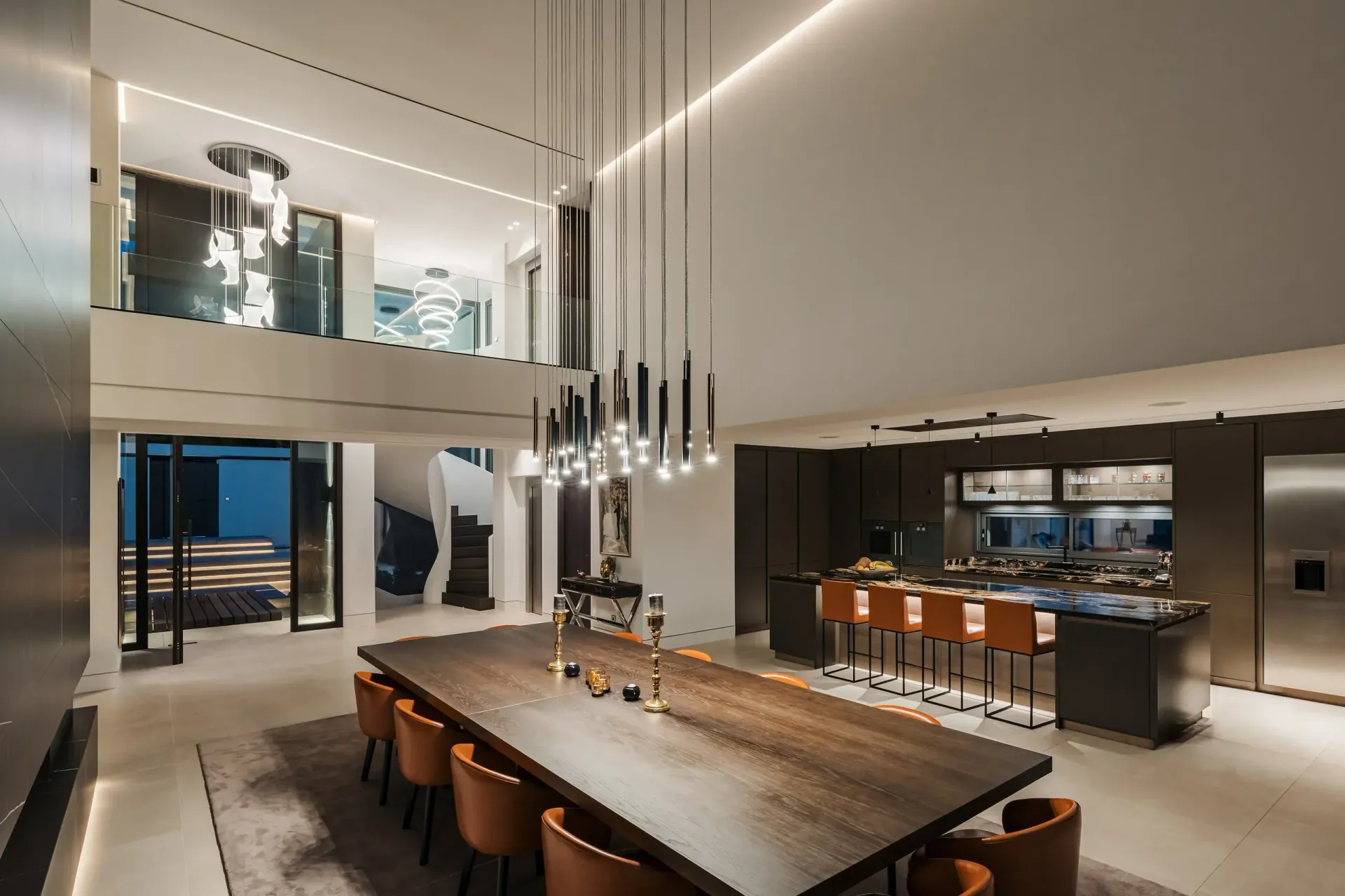 Cocina y comedor de concepto abierto con mesa larga, iluminación moderna y un loft.