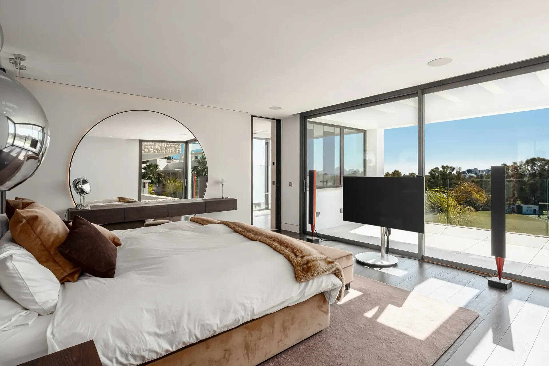 Dormitorio luminoso con cama grande, ventana con vistas, TV y espejo grande.