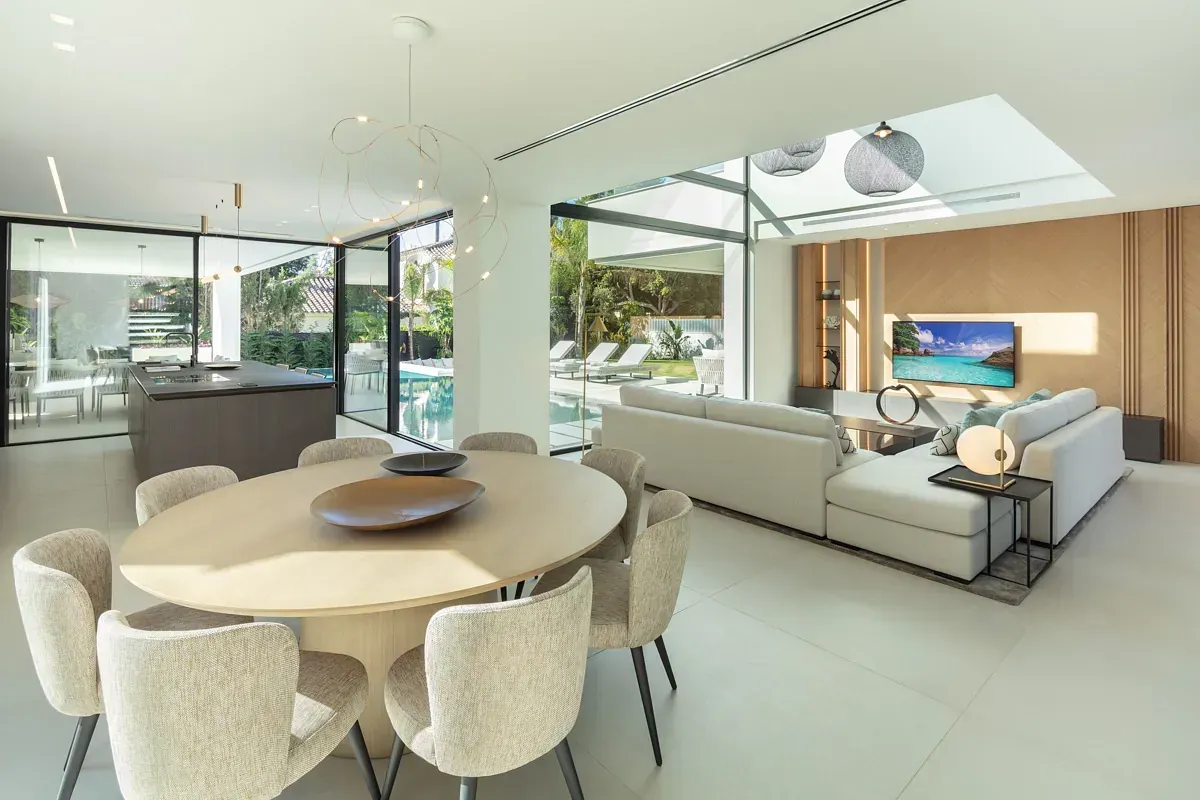 Amplia y moderna sala de estar con comedor, cocina y salón, con vista a la piscina.