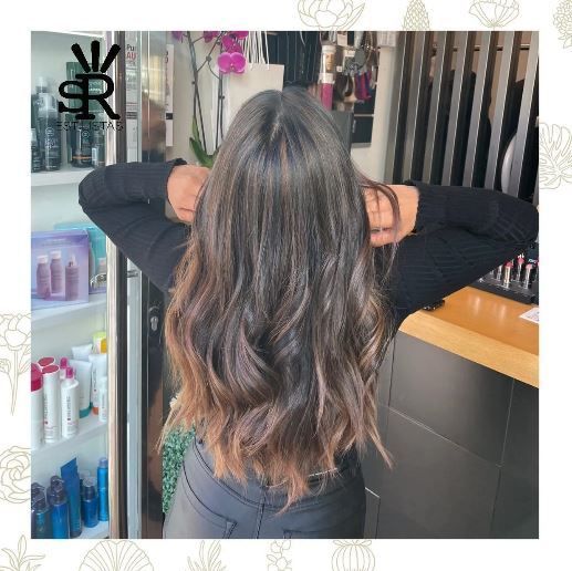 Mujer con cabello castaño largo y ondulado
